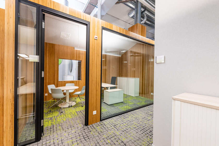 Einzelbüro mit Glaswänden und modernem Mobiliar in weiss