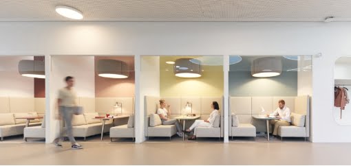 Vier, durch Wände, voneinander getrennte Arbeitsplätze für Gruppenarbeiten ausgestattet mit Lounge Möbeln