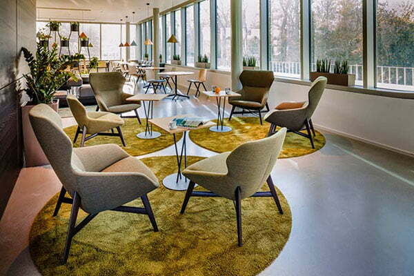 Ockerfarbene Lounge Sessel in einer Social Area als Pausenraum