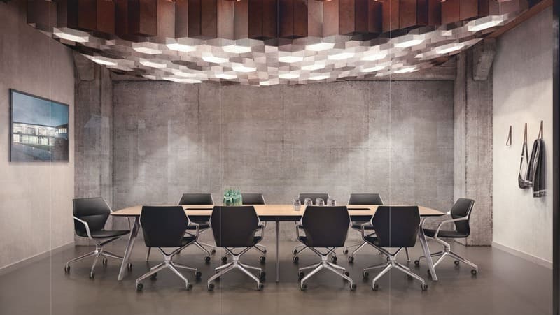 Meetingraum mit großem Konferenztisch und Bürostühlen, besondere Deckenbeleuchtung im Wabenmuster, Betonwände