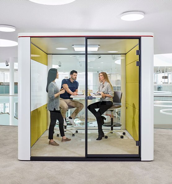 Raum-in-Raum System mit Glasfront für Gruppenarbeiten, drei Personen befinden sich in dem Raum und besprechen etwas