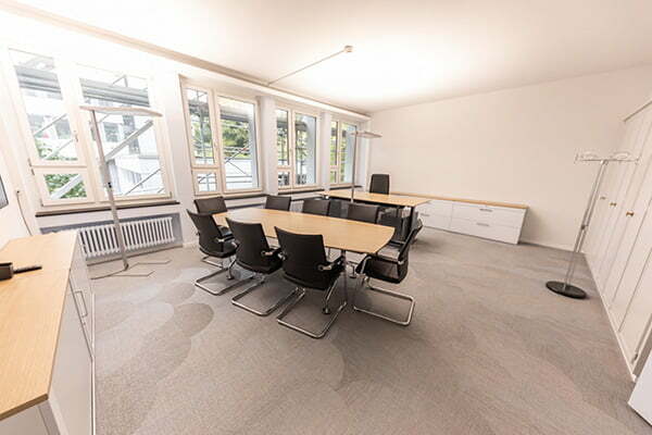 Meetingraum mit großem Tisch, Stühlen und Stauraummöglichkeiten