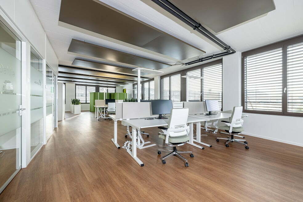 Schlichtes Büro mit weißen Möbeln und dunklem Fussboden