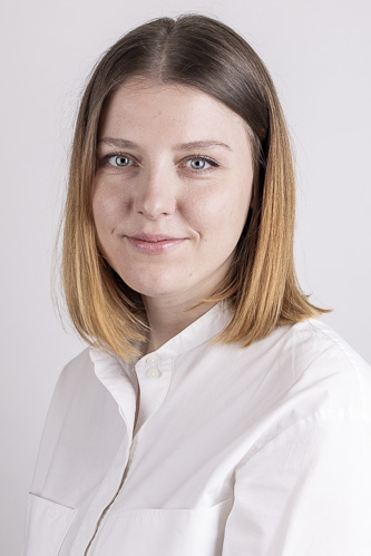 Frau mit schulterlangem Haar und weisser Bluse